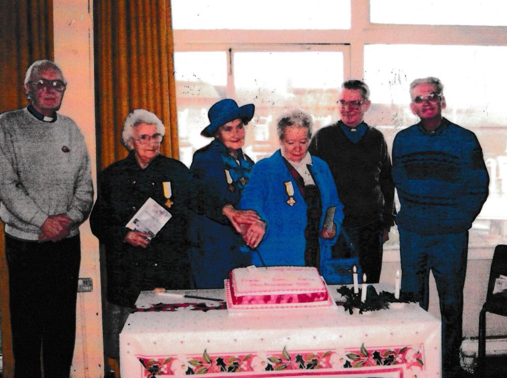 Cutting a cake to celebrate in the old school hall