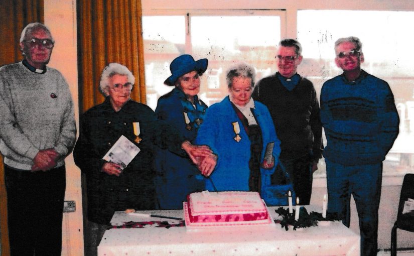 Cutting a cake to celebrate in the old school hall